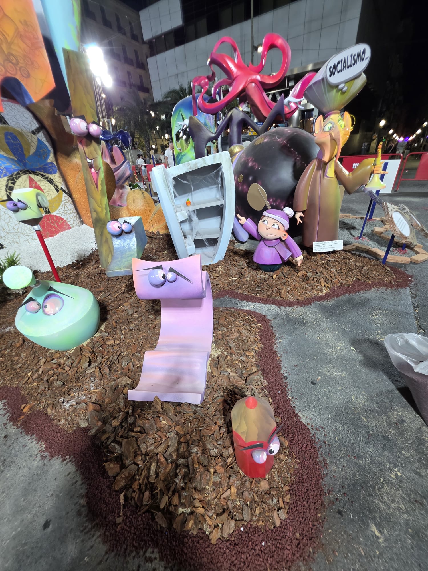 Detalle de la hoguera Mercado Central 2026 con corteza de pino, piedra volcánica roja y plantas decorativas instaladas por BMDP.